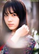 A woman with long black hair and bangs posing for a picture.