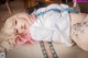 A woman with pink hair laying on a bed.