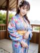 A woman in a blue kimono posing for a picture.