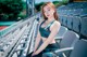 A woman in a sports bra top sitting in a stadium.