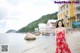 A woman in a red dress standing on a beach.